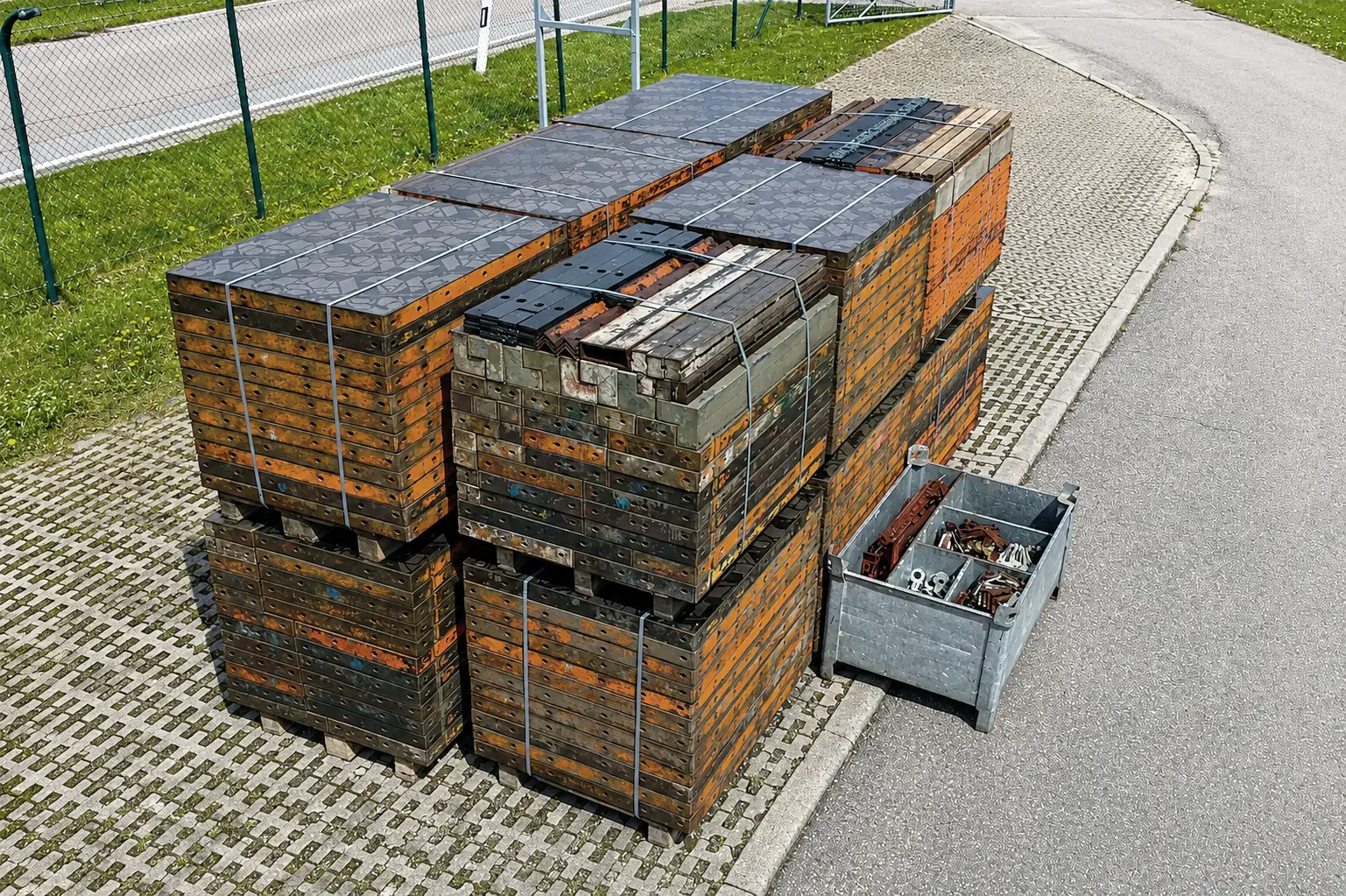 Schaltafeln gebündelt auf Paletten, daneben eine Gitterbox mit sortierten Kleinteilen