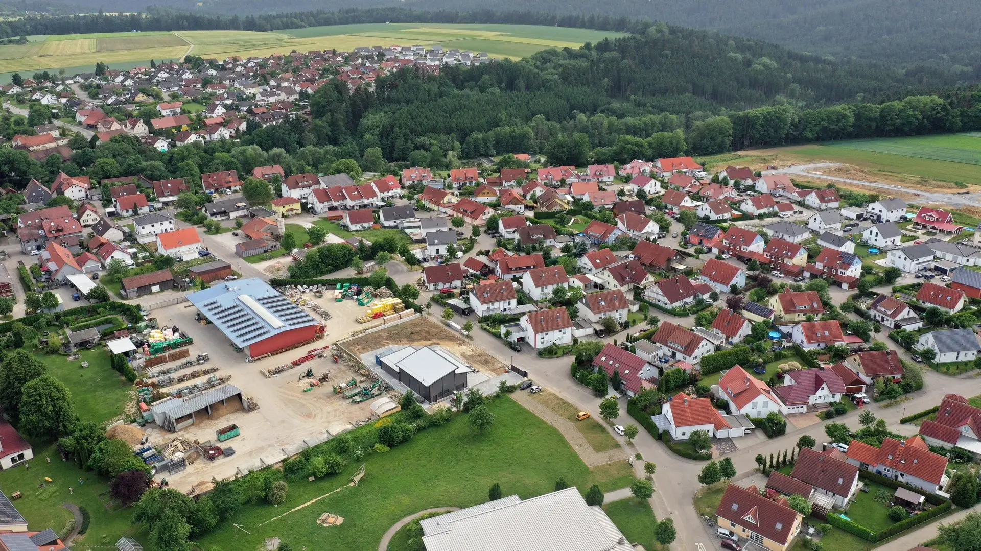 Ruppertshofen im Ostalbkreis aus der Luft: Wohnbebauung, Wald und im Vordergrund das Gewerbegebiet mit Hallen und Lagerflächen